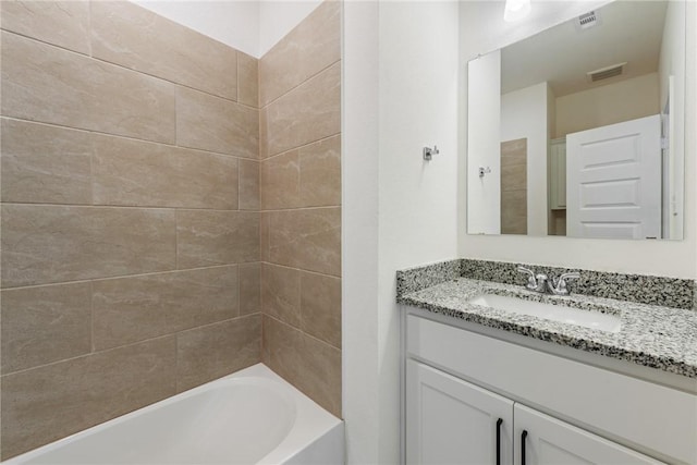 bathroom with vanity and tiled shower / bath combo