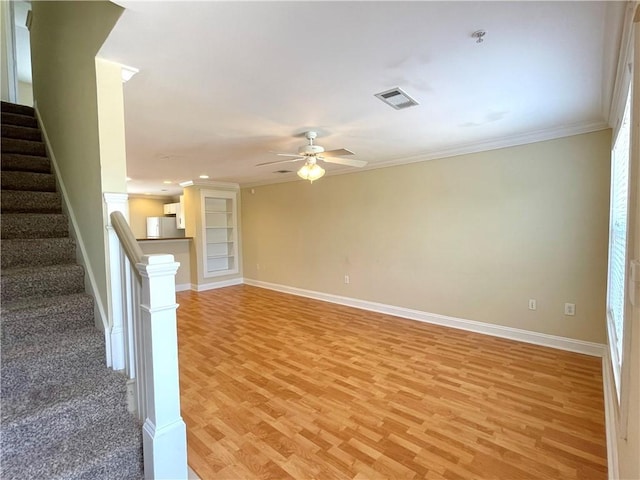 unfurnished living room with crown molding, ceiling fan, and light hardwood / wood-style floors