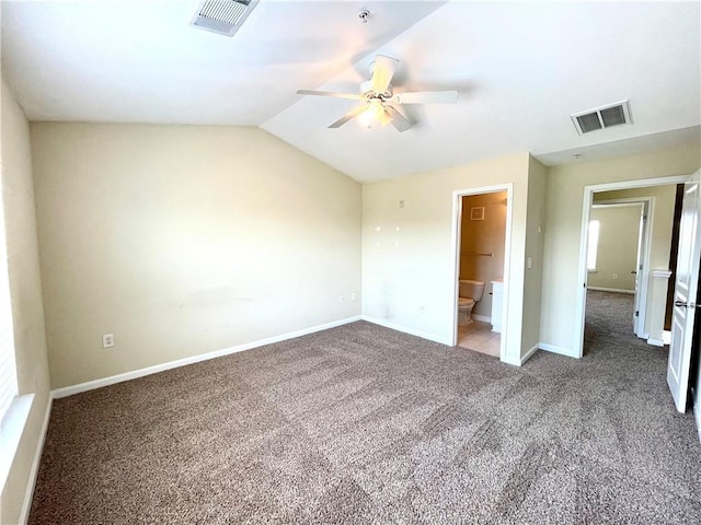 unfurnished bedroom featuring vaulted ceiling, ensuite bathroom, ceiling fan, and carpet