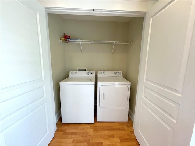 washroom featuring separate washer and dryer and light hardwood / wood-style floors