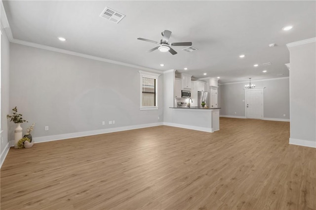 unfurnished living room with ceiling fan with notable chandelier, ornamental molding, and light wood-type flooring