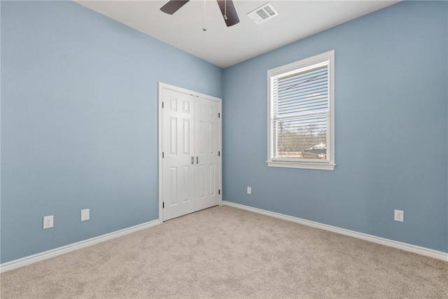 empty room with ceiling fan and light colored carpet