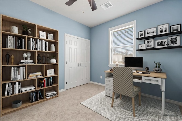 carpeted office space featuring ceiling fan