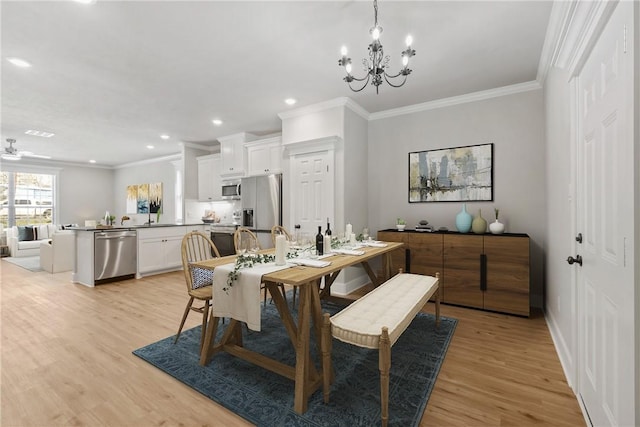 dining room featuring crown molding, ceiling fan with notable chandelier, and light wood-type flooring