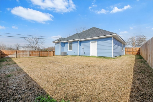 back of property with cooling unit and a yard