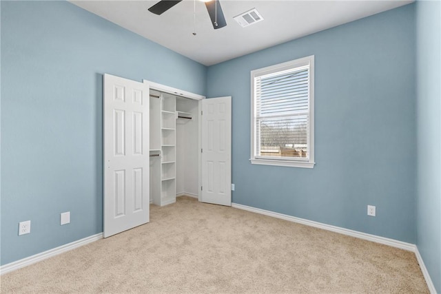 unfurnished bedroom with light carpet, a closet, and ceiling fan