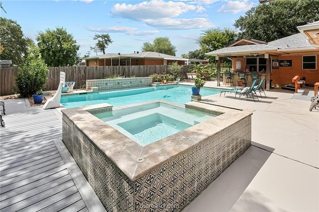 view of pool with a patio area, an in ground hot tub, and an outdoor bar