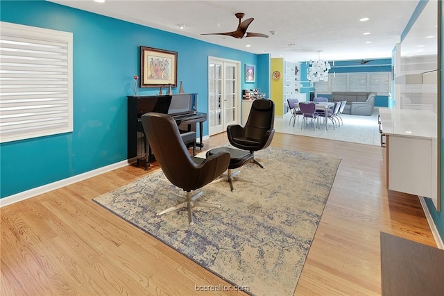 sitting room with ceiling fan and light wood-type flooring