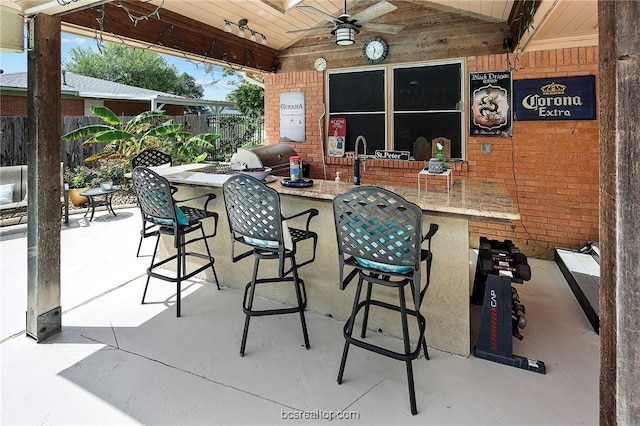 view of patio / terrace featuring exterior bar and ceiling fan