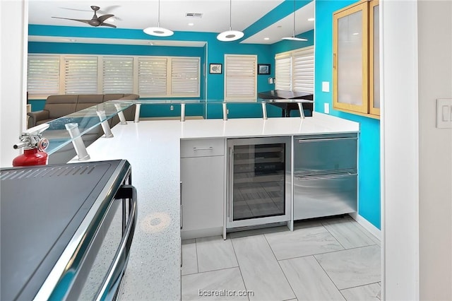 kitchen featuring decorative light fixtures, ceiling fan, and beverage cooler