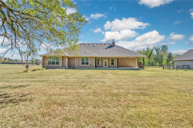 rear view of property with a yard