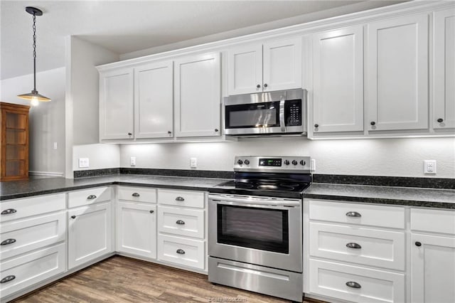 kitchen with pendant lighting, wood-type flooring, white cabinetry, and appliances with stainless steel finishes