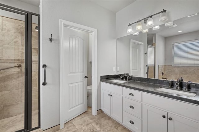 bathroom featuring vanity, toilet, and a shower with door