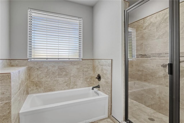 bathroom featuring independent shower and bath and a healthy amount of sunlight