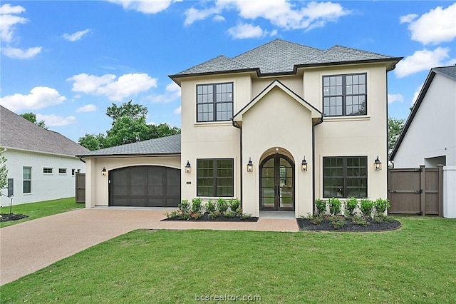 view of front facade with a garage, a front yard, and french doors