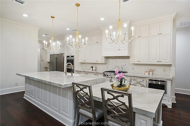 kitchen with a large island, stainless steel appliances, and decorative light fixtures