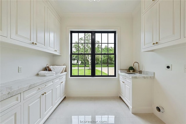 clothes washing area featuring sink, cabinets, electric dryer hookup, crown molding, and light tile patterned flooring