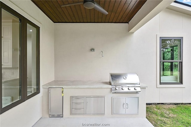 view of patio / terrace with area for grilling, ceiling fan, and an outdoor kitchen