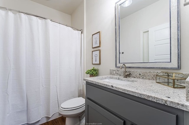 bathroom featuring wood-type flooring, vanity, and toilet