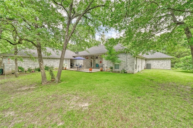 5303 Creek Ln, College Station, TX 77845 - rear view of property with a patio, central air condition unit, a yard, a shingled roof, and brick siding