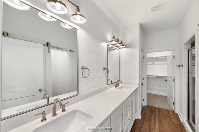 bathroom with vanity, wood-type flooring, and a shower with shower door