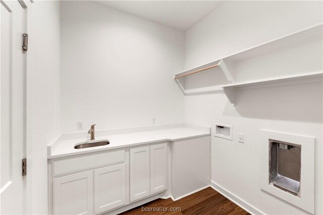 laundry area featuring cabinets, sink, washer hookup, and dark hardwood / wood-style floors