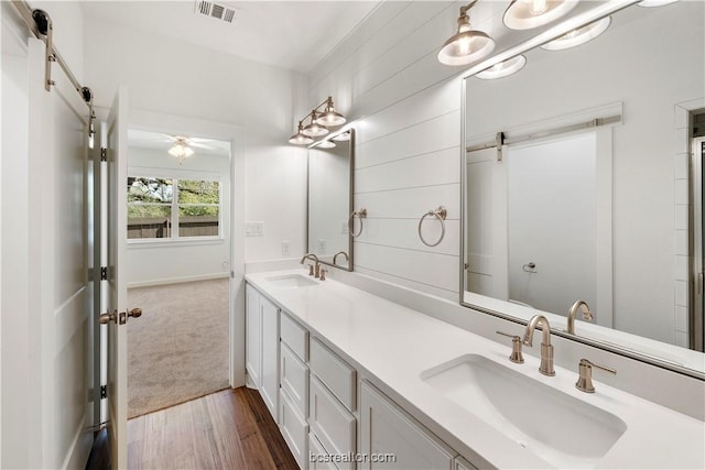 bathroom with ceiling fan, vanity, and wood-type flooring