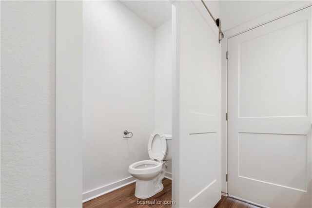 bathroom with hardwood / wood-style floors and toilet