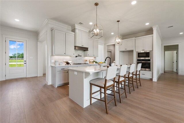 7800 Mathis Creek Dr, Bryan, TX 77808 - kitchen featuring recessed lighting, ornamental molding, gas stovetop, and light wood-type flooring