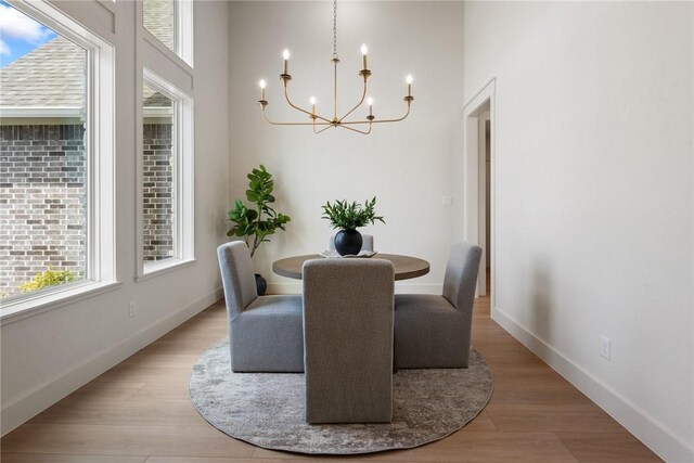 7800 Mathis Creek Dr, Bryan, TX 77808 - dining space with an inviting chandelier, baseboards, wood finished floors, and a towering ceiling