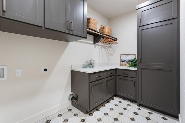 7800 Mathis Creek Dr, Bryan, TX 77808 - laundry area featuring baseboards, electric dryer hookup, cabinet space, and light floors