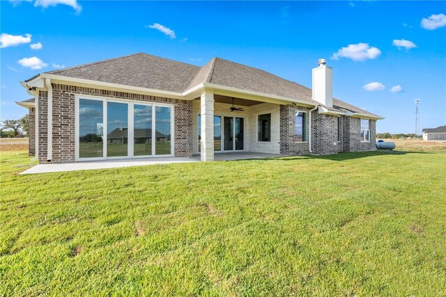 7800 Mathis Creek Dr, Bryan, TX 77808 - back of property featuring brick siding, ceiling fan, a chimney, a lawn, and a patio