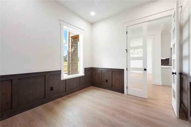 empty room with french doors and light hardwood / wood-style flooring