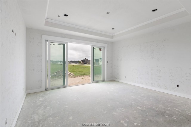 empty room featuring a tray ceiling and crown molding