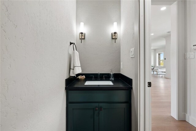 7800 Mathis Creek Dr, Bryan, TX 77808 - bathroom with a textured wall, wood finished floors, and vanity