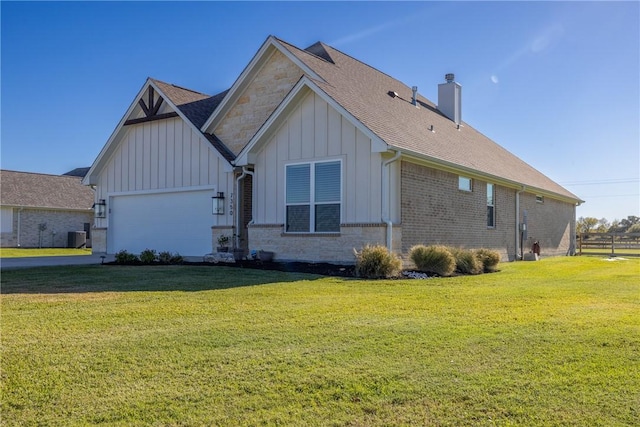 view of front facade with a front yard, central AC, and a garage