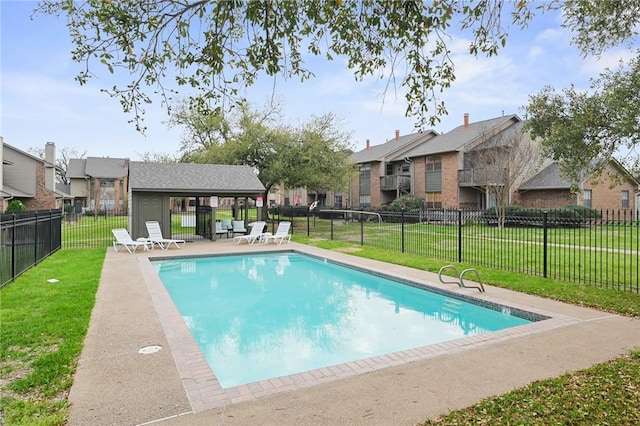 view of pool with a patio and a lawn