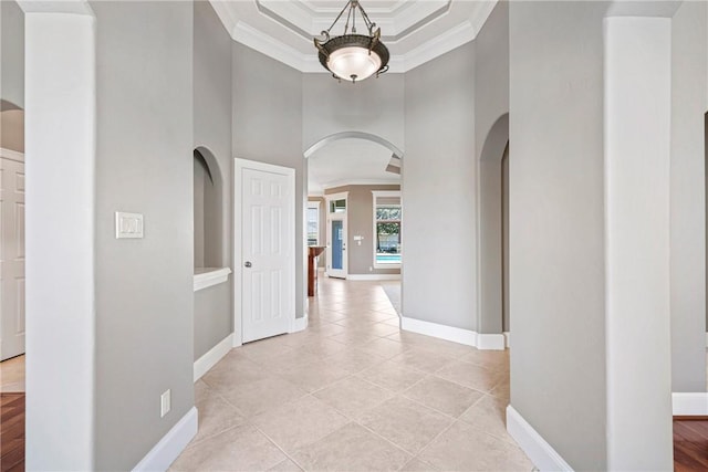 5106 Bellerive Bend Dr, College Station, TX 77845 - hallway featuring light tile patterned flooring, baseboards, arched walkways, a towering ceiling, and ornamental molding