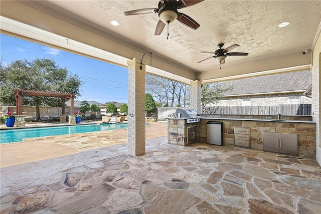 5106 Bellerive Bend Dr, College Station, TX 77845 - view of patio featuring exterior kitchen, area for grilling, a fenced in pool, a fenced backyard, and a ceiling fan