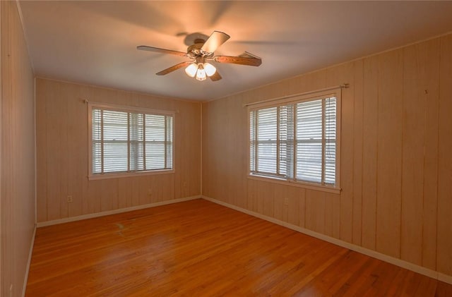 spare room featuring hardwood / wood-style flooring, plenty of natural light, and ceiling fan