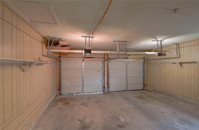 garage with a garage door opener and wood walls