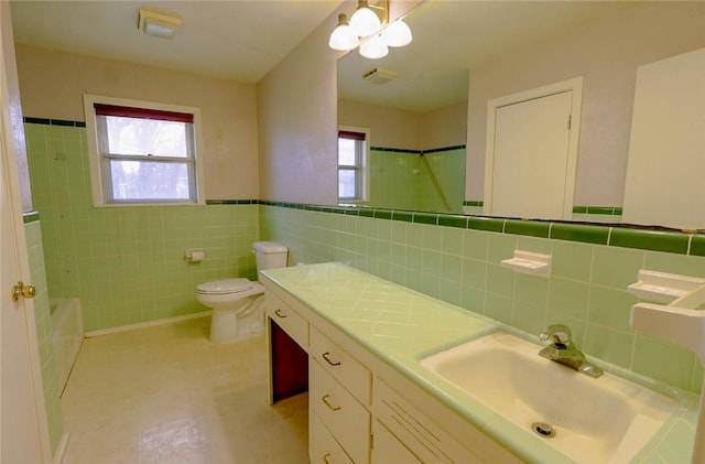 full bathroom with vanity, a healthy amount of sunlight, tile walls, and toilet