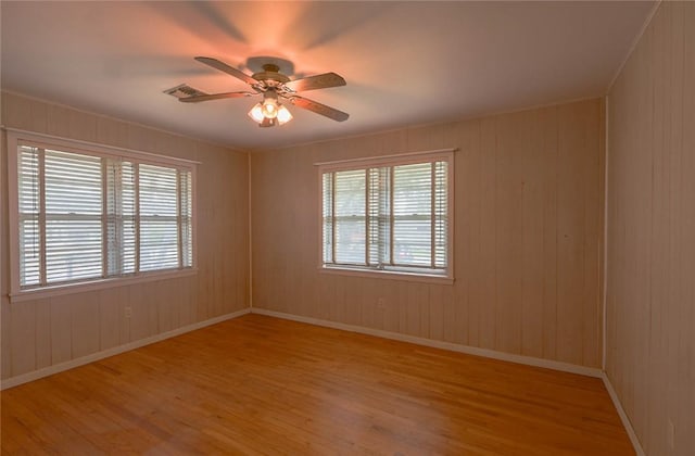 spare room featuring light hardwood / wood-style flooring, plenty of natural light, and ceiling fan