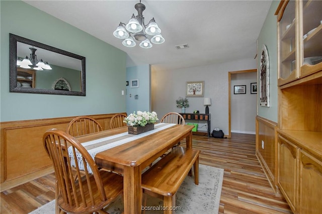 dining room with light hardwood / wood-style flooring and a notable chandelier