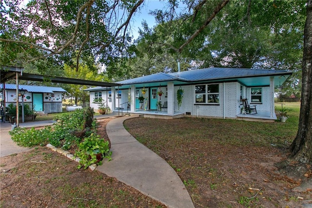 ranch-style house with covered porch and an outdoor structure