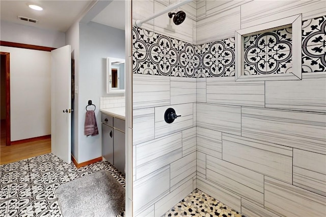 bathroom featuring vanity, wood-type flooring, and tiled shower