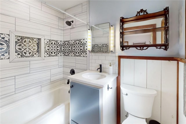 full bathroom featuring vanity, tiled shower / bath combo, and toilet