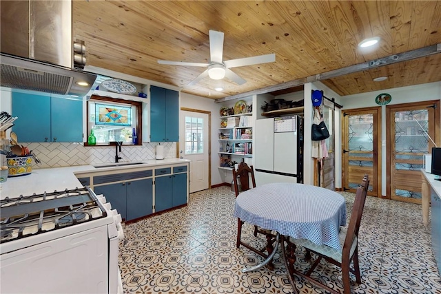 kitchen with gas range gas stove, ceiling fan, sink, blue cabinets, and decorative backsplash