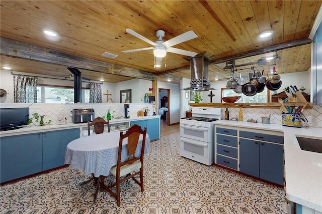 kitchen with island range hood, blue cabinets, white range with gas cooktop, and tasteful backsplash