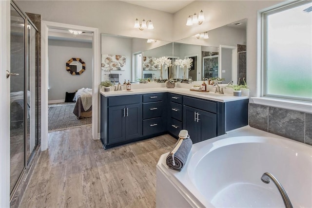 bathroom featuring vanity, wood-type flooring, and shower with separate bathtub